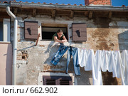 Девушка вешает белье на пятом этаже (2008 год). Редакционное фото, фотограф Pukhov K / Фотобанк Лори