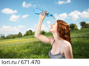Девушка в парке льет себе на лицо воду. Стоковое фото, фотограф Raev Denis / Фотобанк Лори