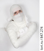 Человек в бинтах прорывается через белую бумагу. Стоковое фото, фотограф pzAxe / Фотобанк Лори
