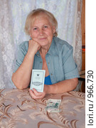 Пожилая женщина с деньгами и сберкнижкой (2009 год). Редакционное фото, фотограф GANG / Фотобанк Лори