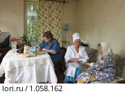 Социальный работник у пенсионера дома (2009 год). Редакционное фото, фотограф Дмитрий Неумоин / Фотобанк Лори