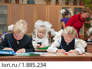 Учительница помогает первоклассникам на уроке (2009 год). Редакционное фото, фотограф Кекяляйнен Андрей / Фотобанк Лори