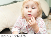 Маленькая девочка сидит на диване, увлеченно смотрит вперед. Стоковое фото, фотограф Кекяляйнен Андрей / Фотобанк Лори