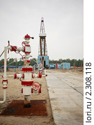 Скважина для добычи нефти и газа на фоне буровой установки. Стоковое фото, фотограф Rumo / Фотобанк Лори