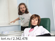 Задумавшаяся врач сидит в кресле, не обращая внимания на больного пациента. Стоковое фото, фотограф Юрий Шаньшин / Фотобанк Лори