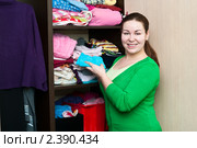 Женщина укладывает вещи в шкафу. Стоковое фото, фотограф Кекяляйнен Андрей / Фотобанк Лори