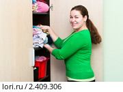 Женщина укладывает вещи в шкафу. Стоковое фото, фотограф Кекяляйнен Андрей / Фотобанк Лори