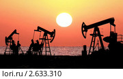 Работающие нефтяные насосы на фоне выходящего из моря солнца. Стоковое видео, видеограф Михаил Коханчиков / Фотобанк Лори