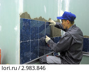 Рабочий укладывает кафельную плитку (2011 год). Редакционное фото, фотограф Владимир Горощенко / Фотобанк Лори