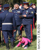 Девочка собирает цветы на фоне казаков (2011 год). Редакционное фото, фотограф Виктор Филиппович Погонцев / Фотобанк Лори