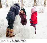 Три девочки подружки строят снеговика в лесу. Стоковое фото, фотограф Игорь Низов / Фотобанк Лори