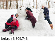 Три девочки и мальчик рядом с построенными снеговиками. Стоковое фото, фотограф Игорь Низов / Фотобанк Лори