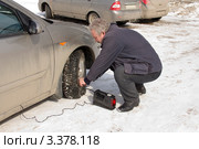 Мужчина подключает насос для подкачки колеса автомобиля. Стоковое фото, фотограф Дудакова / Фотобанк Лори