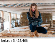 Симпатичная девушка  сидит в сарае на бревнах зимой. Стоковое фото, фотограф Игорь Низов / Фотобанк Лори