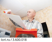 Мужчина приклеивает потолочную плитку. Стоковое фото, фотограф Яков Филимонов / Фотобанк Лори