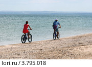 Девушка и парень едут на велосипедах по берегу вдоль моря. Стоковое фото, фотограф Щеголева Ольга / Фотобанк Лори