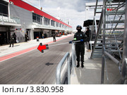 Член команды показывает автомобилю заезд в питлейн на трассе Moscow Raceway в Подмосковье (2012 год). Редакционное фото, фотограф Николай Винокуров / Фотобанк Лори