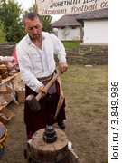 Сорочинская ярмарка. Кузнец чеканит монету. (2012 год). Редакционное фото, фотограф Олег Голиков / Фотобанк Лори