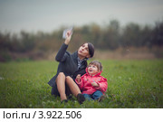 Мама с дочкой запускают бумажный самолетик на лугу. Стоковое фото, фотограф Наталья Чуб / Фотобанк Лори