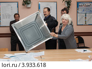 Сотрудники участковой избирательной комиссии показывают наблюдателям на выборах опустошенную стационарную урну для голосования после изъятия из нее избирательных бюллетеней. Единый день голосования (2012 год). Редакционное фото, фотограф А. А. Пирагис / Фотобанк Лори