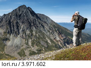 Турист фотографирует горы на Камчатке. Горный массив Вачкажец (2012 год). Редакционное фото, фотограф А. А. Пирагис / Фотобанк Лори