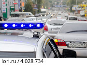 Полицейский автомобиль со спецсигналами в потоке автомобилей на городской улице, фрагмент. Ростов-на-Дону (2012 год). Редакционное фото, фотограф Олег Пчелов / Фотобанк Лори