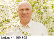 Портрет пожилого мужчины на фоне цветущего сада. Стоковое фото, фотограф Дарья Трофимова / Фотобанк Лори