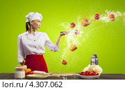 Красивая восточная девушка в белом поварском колпаке на кухне рассекает ножом каскад яблок и болгарских перцев в воздухе. Стоковое фото, фотограф Sergey Nivens / Фотобанк Лори