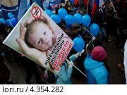 Плакат с надписью "Ювенальной юстиции не место в России" держит активист на "Марше в защиту детей" в городе Москве (2013 год). Редакционное фото, фотограф Николай Винокуров / Фотобанк Лори