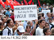 Женщина держит плакат с надписью на английском языке "Список Магнитского - первый шаг к Гаагскому трибуналу" на митинге в защиту политзаключенных (2012 год). Редакционное фото, фотограф Николай Винокуров / Фотобанк Лори
