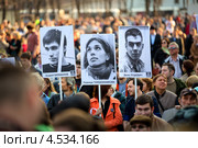 Участники митинга держат фотографии политзаключенных Андрея Барабанова,  Надежды Толоконниковой, Дениса Луцкевича на митинге 17 апреля "В поддержку политзаключенных" в Новопушкинском сквере города Москвы (2013 год). Редакционное фото, фотограф Николай Винокуров / Фотобанк Лори