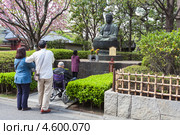 Японская семья молиться одной из статуй Будды в Senso-ji shrine, Asakusa, Токио. Япония (2013 год). Редакционное фото, фотограф Кекяляйнен Андрей / Фотобанк Лори