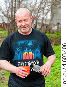 Мужчина наливает водку из бутылки в стакан на природе (2013 год). Редакционное фото, фотограф Игорь Низов / Фотобанк Лори