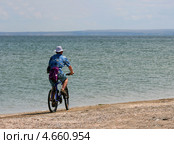 Мужчина едет на велосипеде вдоль берега моря (2012 год). Стоковое фото, фотограф Щеголева Ольга / Фотобанк Лори