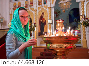 Девушка ставит свечку в православном храме. Стоковое фото, фотограф Андрей Ярославцев / Фотобанк Лори