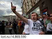 Мужчина в футболка с призывом "Свободу политзаключенным" показывает руку в сторону движущихся автомобилей по Тверской улице города Москвы 18 июля 2013. Редакционное фото, фотограф Николай Винокуров / Фотобанк Лори
