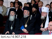Святейшие Патриархи Феофил III и Хризостом II и Блаженнейший Митрополит Савва сидят на трибуне для зрителей концерта, посвященного 1025-летию Крещения Руси на Красной площади в городе Москве, Россия (2013 год). Редакционное фото, фотограф Николай Винокуров / Фотобанк Лори
