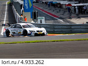 Автомобиль BMW M3 DTM (пилот Martin Tomczyk) на фоне питлейонов трассы Moscow Raceway в Подмосковье 3 августа 2013. Редакционное фото, фотограф Николай Винокуров / Фотобанк Лори