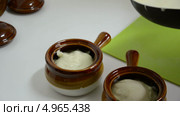 Большой ложкой разливаем из сковороды соус морнэ по глиняным горшочкам. Стоковое видео, видеограф verbaska / Фотобанк Лори