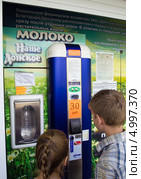 Люди у автомата для продажи молока, город Воронеж (2013 год). Редакционное фото, фотограф Вячеслав Палес / Фотобанк Лори