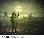Выживший в ядерной войне показывает рукой на знак радиации. Стоковое фото, фотограф Sergey Nivens / Фотобанк Лори