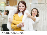 Девушка в магазине примеряет шубку из белого меха. Стоковое фото, фотограф Яков Филимонов / Фотобанк Лори