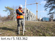 Топограф на фоне стройки. Стоковое фото, фотограф Phovoir Images / Фотобанк Лори