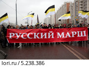 Национастически настроенная молодежь держит имперские флаги и баннер с надписью "Русский марш" на шествии националистов в районе Люблино города Москвы, 4 ноября 2013. Редакционное фото, фотограф Николай Винокуров / Фотобанк Лори