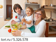 Счастливые родители с ребенком на кухне готовят салат. Стоковое фото, фотограф Юлия Кузнецова / Фотобанк Лори
