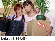Подруги переносят растения при переезде. Стоковое фото, фотограф Phovoir Images / Фотобанк Лори