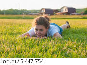 Девушка лежит на траве на фоне коттеджей. Стоковое фото, фотограф Игорь Низов / Фотобанк Лори