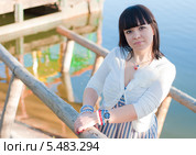 Девушка стоит у деревянных перил у воды. Стоковое фото, фотограф Елизавета Александрова / Фотобанк Лори