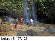 Туристы на фоне водопада Сайок Ной (Sai Yok Waterfall). Национальный парк Сай Йок, Канчанабури, Королевство Таиланд (2013 год). Редакционное фото, фотограф Григорий Писоцкий / Фотобанк Лори