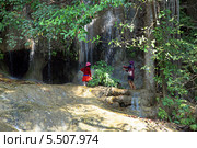 Туристы на фоне водопада Сайок Ной (Sai Yok Waterfall). Национальный парк Сай Йок, Канчанабури, Королевство Таиланд (2013 год). Стоковое фото, фотограф Григорий Писоцкий / Фотобанк Лори